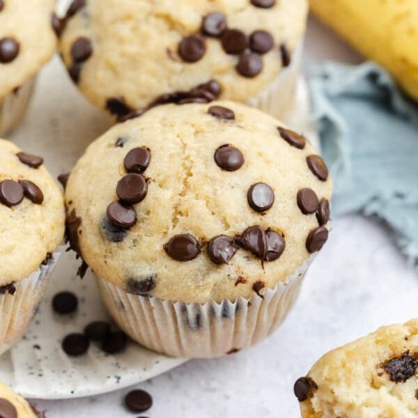 muffins on a plate with chocolate chips on top.