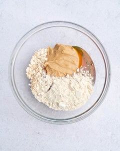 ingredients for peanut butter protein oat cups placed in a bowl.