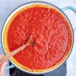 arrabiata sauce in a pan with a spoon in the sauce.
