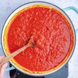 arrabiata sauce in a pan with a spoon in the sauce.