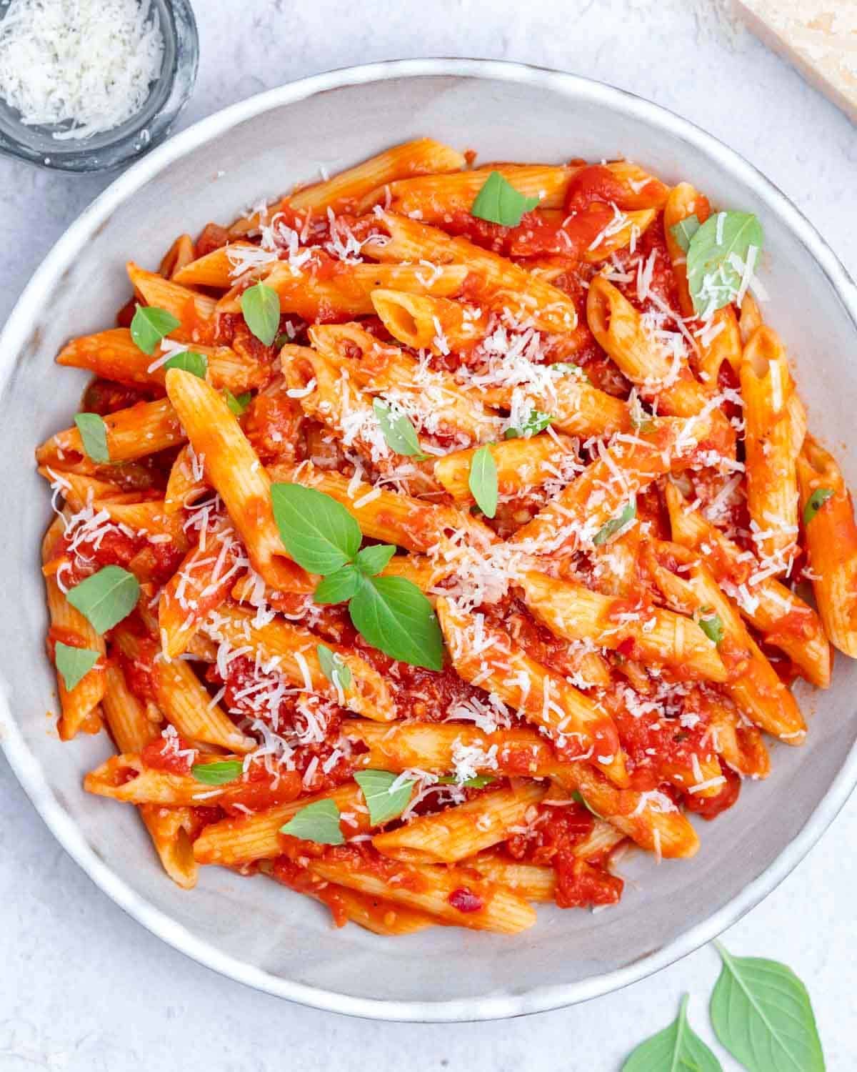 arrabbiata sauce served with pasta in a dish topped with fresh basil.