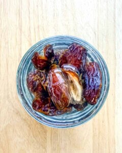 dates being soaked in a cup.