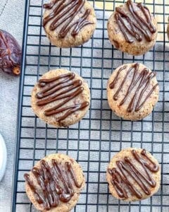 cookies on a rack cooling with drizzled chocolate.