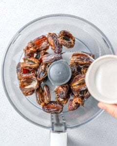 water being added to the dates in the food processor.