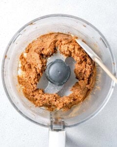 scraping down the date paste in the food processor.
