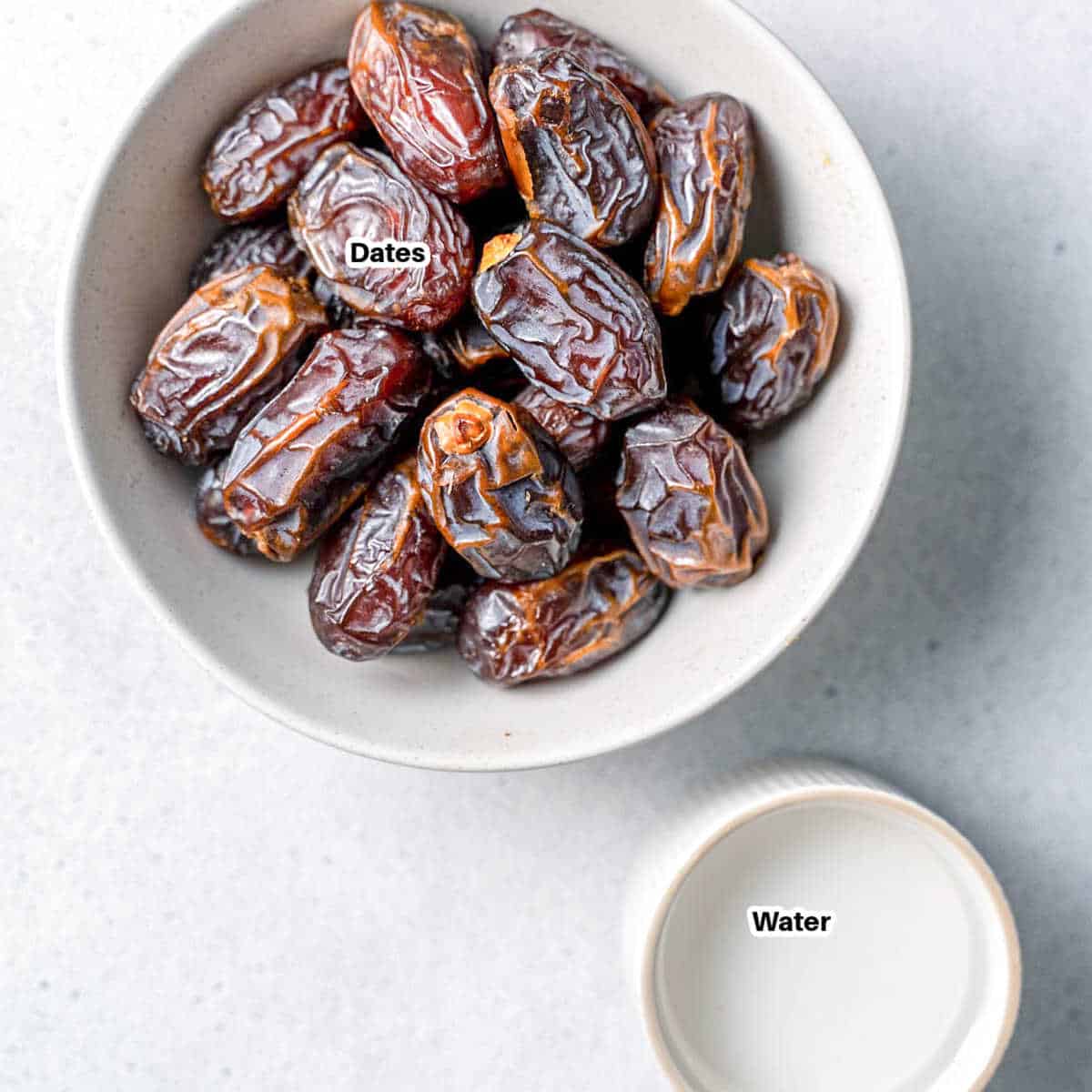 dates in a bowl and a small bowl of water to make date paste.