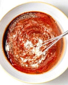 mixing seasonings with ketchup to make cocktail sauce.