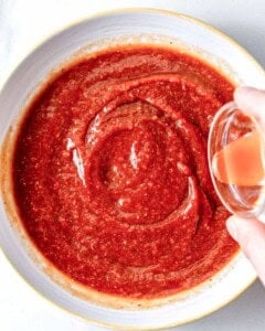 hot sauce being added over the cocktail sauce.