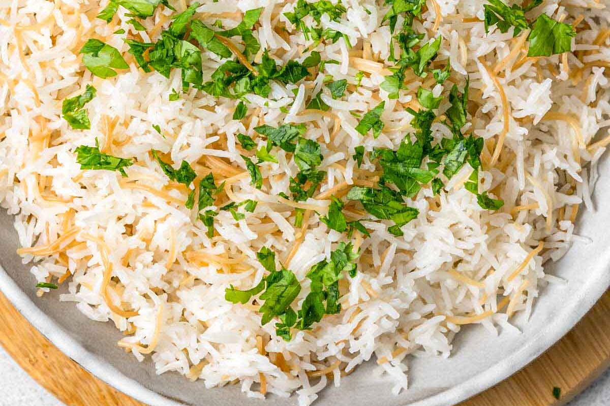 a bowl of lebanese rice in a bowl topped with chopped parsley.