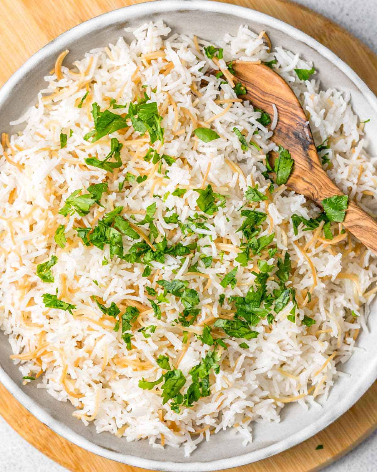 a bowl of rice with wooden spoon in it.