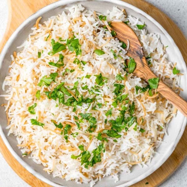 lebanese rice in a bowl topped with chopped parsley.