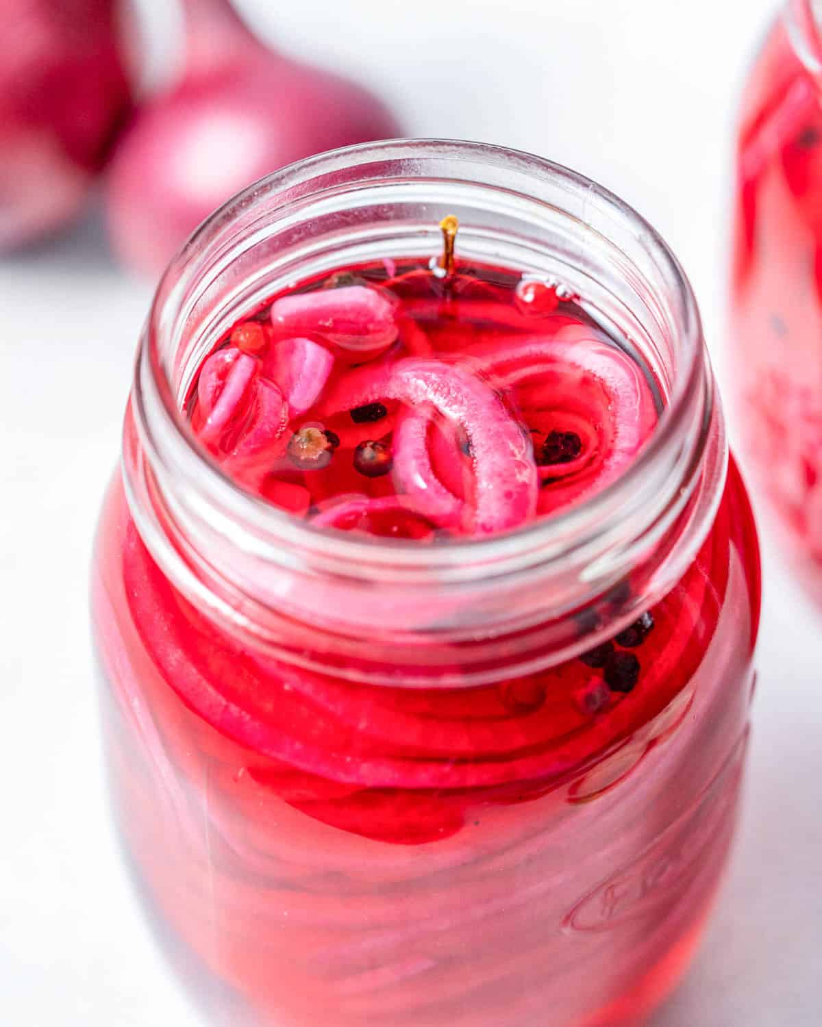 pickled red onions in a jar with the brine.