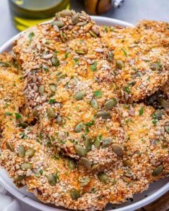 Seeded air fryer chicken cutlets on a white plate.