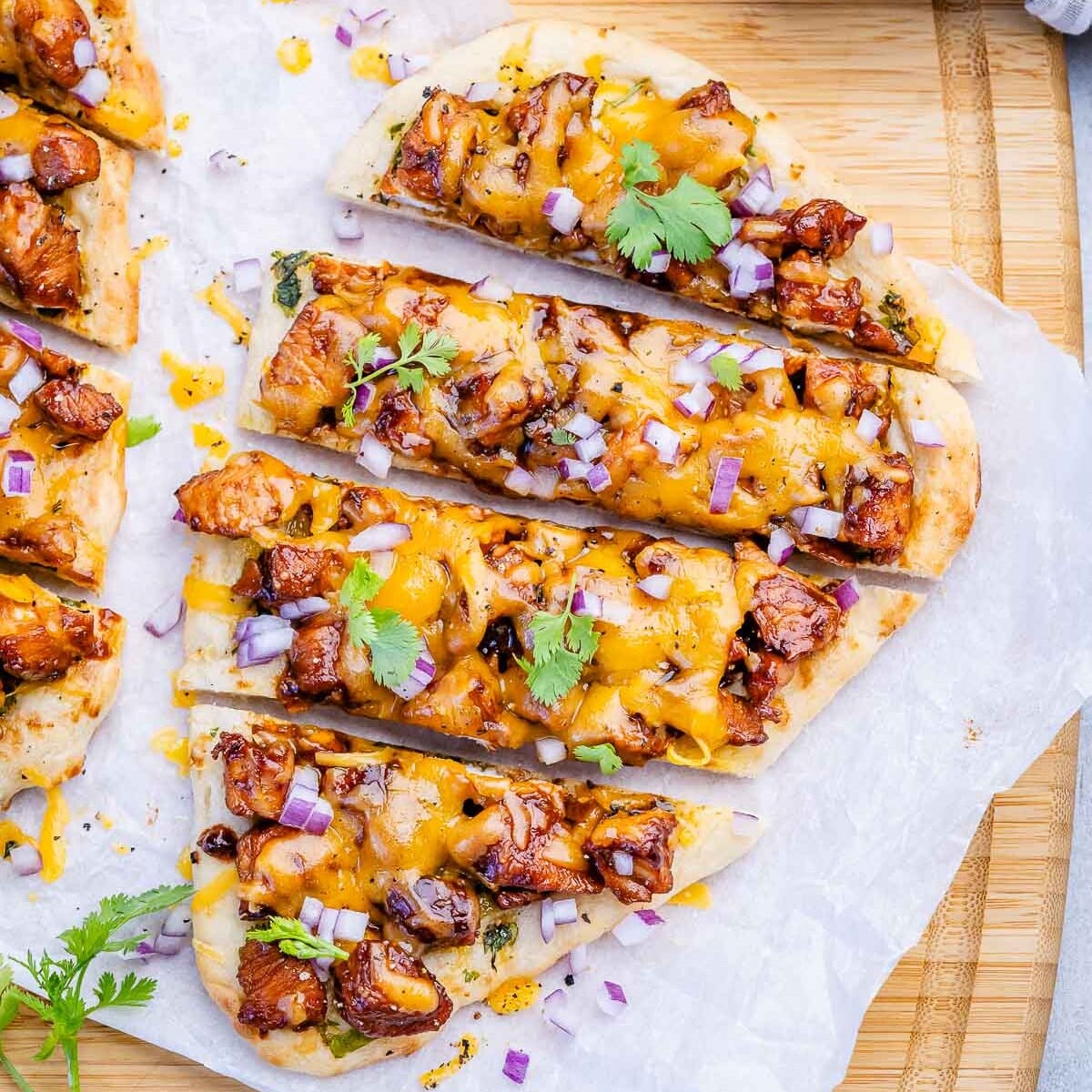 sliced bbq chicken flatbread on parchment paper.