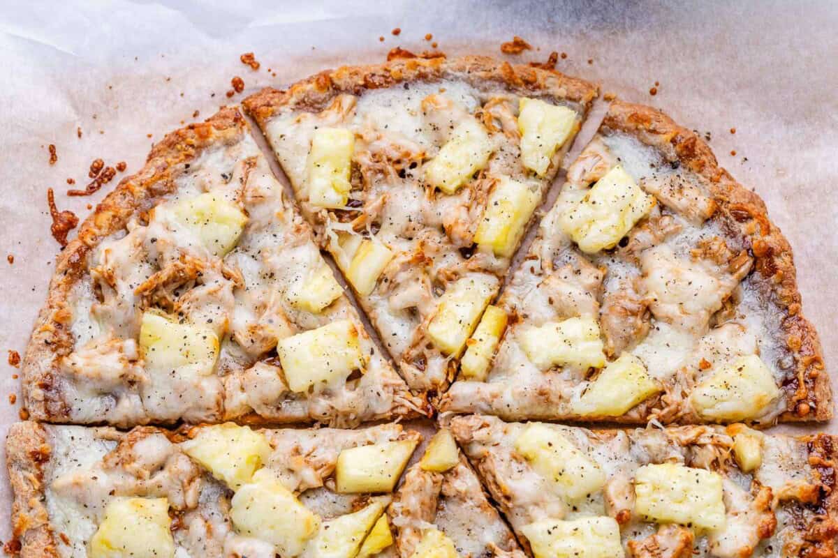 Sliced BBQ chicken pizza topped with pineapple.