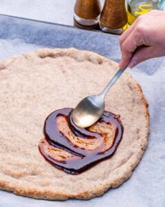 Adding BBQ sauce over the baked dough.