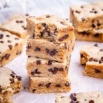 cookie bars stacked over each other on parchment paper.