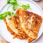 two quesadilla halves on a plate stuffed with chipotle chicken.