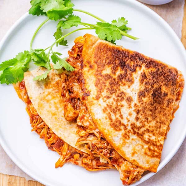 two quesadilla halves on a plate stuffed with chipotle chicken.