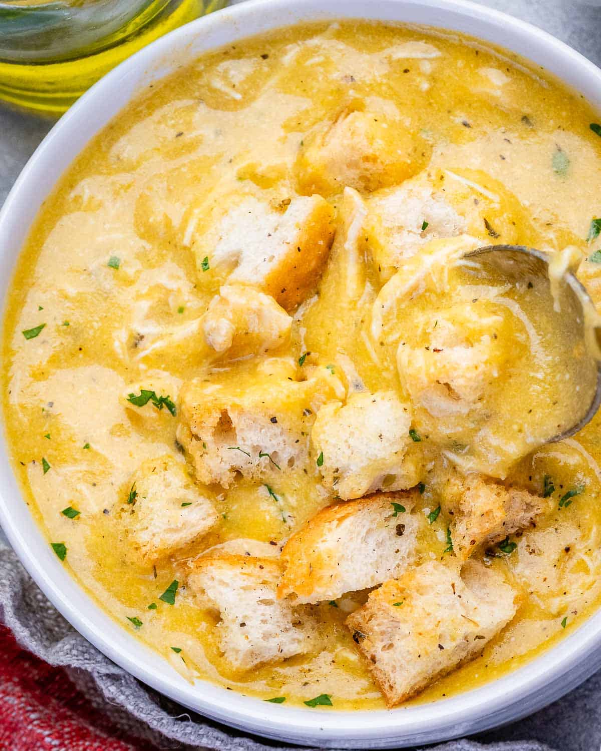 A bowl of homemade cream of chicken soup with a spoon.