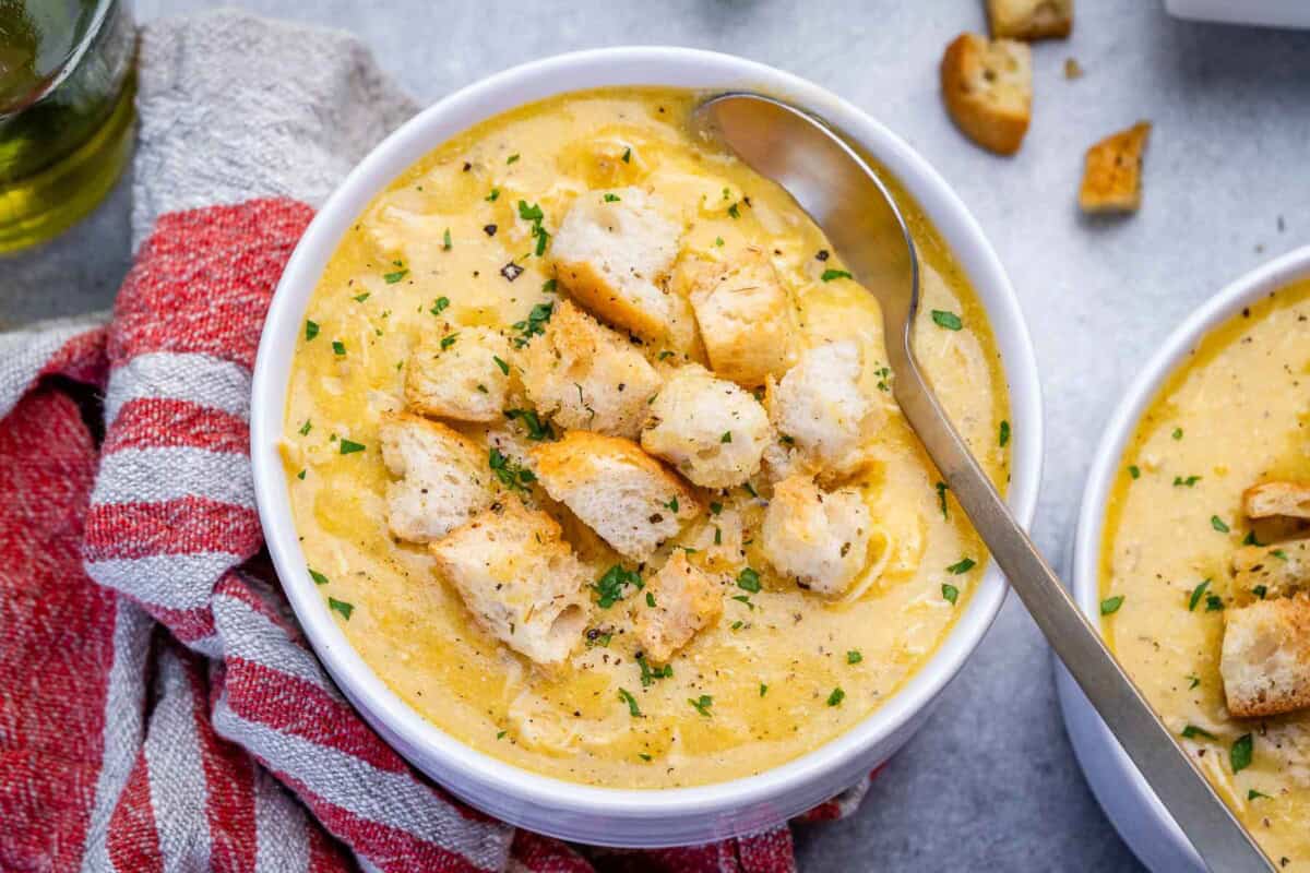 a bowl of cream of chicken soup with wooden spoon in the bowl.