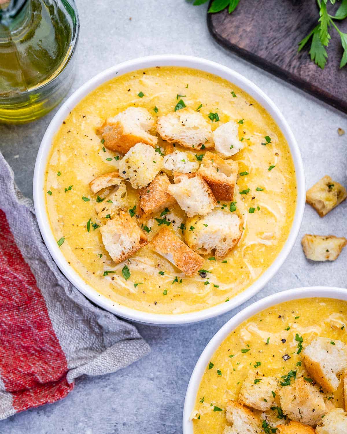 Cream of chicken soup in a white bowl topped with croutons.