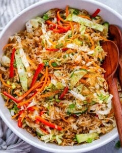 mixing the salad with a wooden spoon in a bowl.