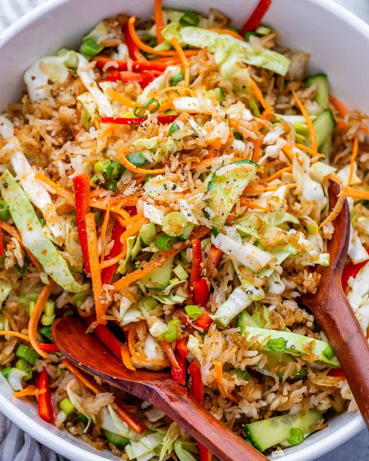 spoon in a bowl filled with crispy rice and veggie salad.