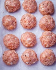 chicken meatballs formed and placed on a sheetpan.