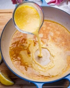 broth being added over the seasoned pan after cooking the meatballs.