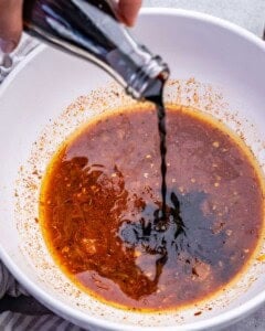 adding the marinade ingredients to a bowl.