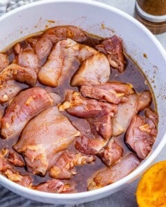 chicken marinating in a bowl.