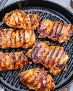 chicken thighs grilled on a pan.