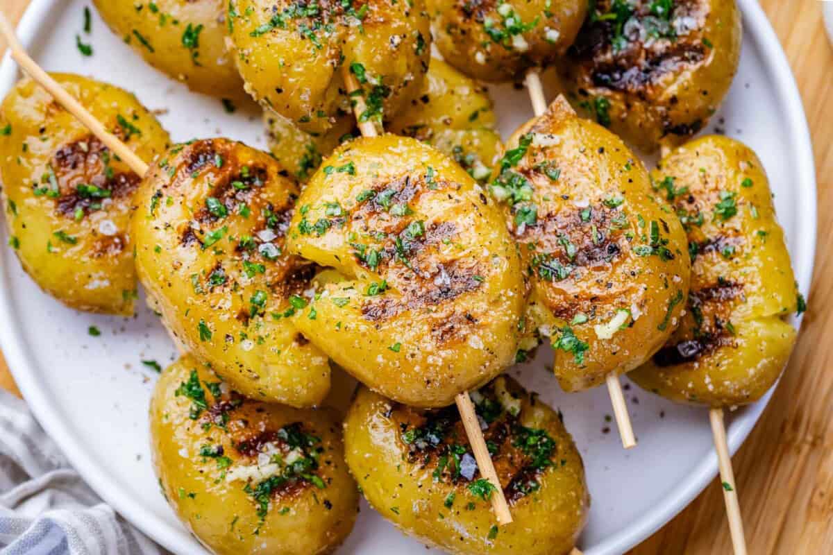 grilled potatoes on skewers on a plate.