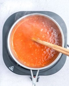 Cooking the enchilada sauce in a pan.