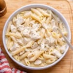 chicken alfredo with penne pasta served in a round white bowl.