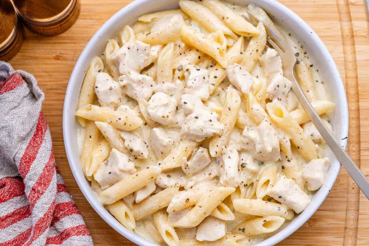 Chicken alfredo in a bowl with a spoon in it.