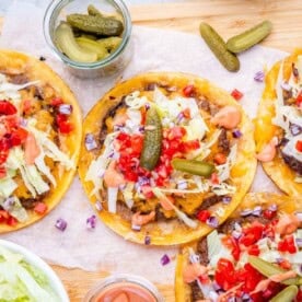 smash burger tacos laid out with burger toppings.