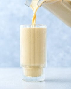 pouring the vanilla shake into a cup.