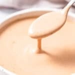 a round bowl with copycat canes sauce with spoonful of sauce over bowl.