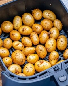 Seasoned potatoes added to the air fryer.