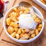a bowl filled with apple bread pudding topped with a serving of ice cream.
