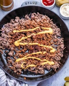cooking the ground beef with seasoning in a skillet.