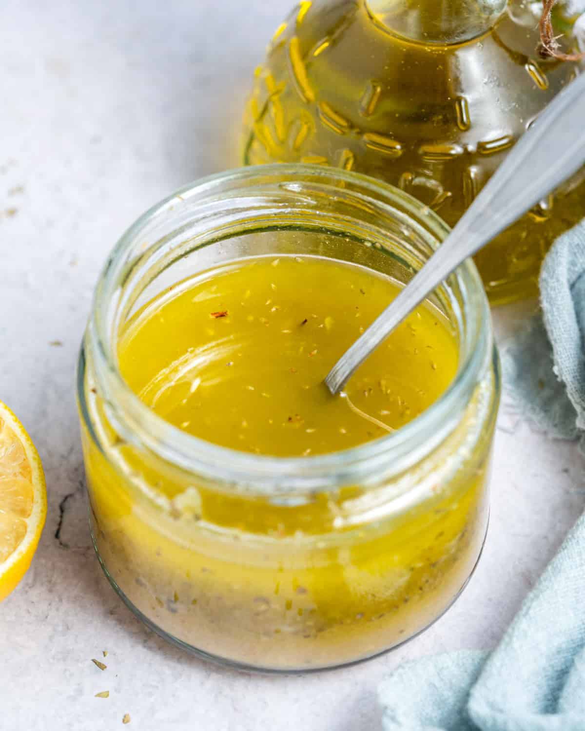 A jar of salad dressing with a spoon in the jar.