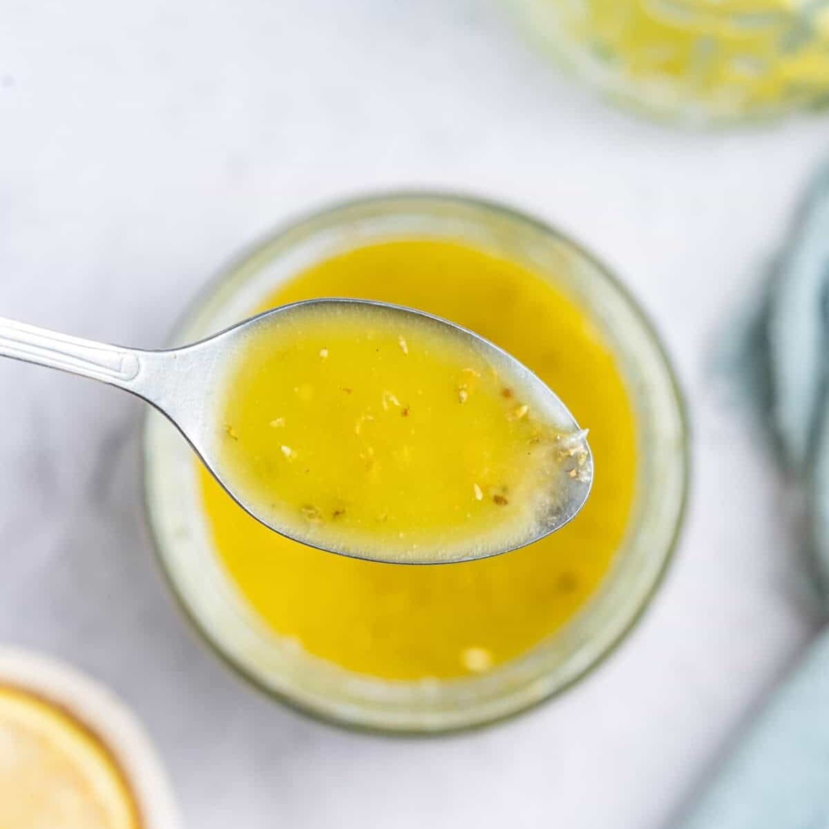 a spoonful of salad dressing in a jar.