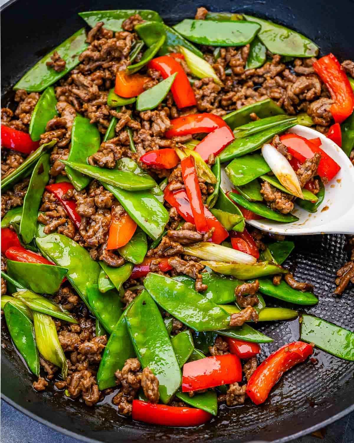 spoon in a skillet with ground beef stir fry.