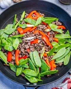 snap peas added over the other veggies and cooked ground beef in a skillet.