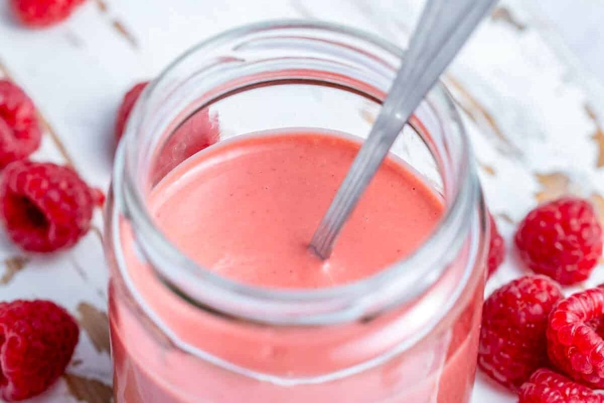 raspberry dressing in a jar with spoon in the jar.