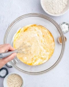 whisking the wet ingredients for the banana muffins in a bowl.