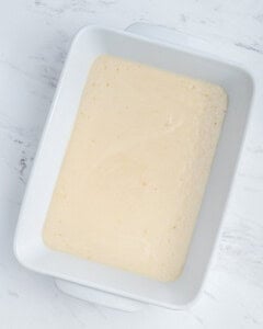 Cobbler batter poured into a baking dish.